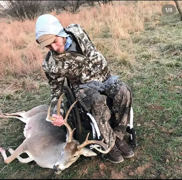 Veteran in a wheelchair posing for a photo with a 10-point buck deer harvested during a hunting trip with the Texas Hunting & Fishing Guides for Veterans nonprofit