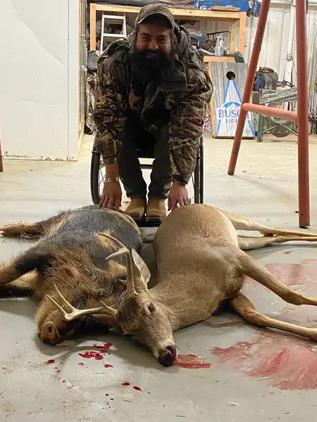 Veteran posing for a photo with two hogs.