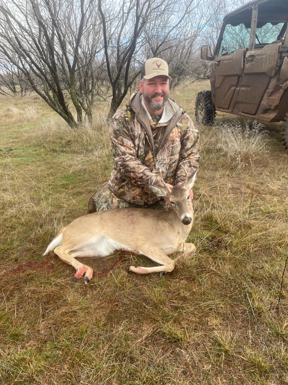 Veteran posing with a harvested deer during a ranch hunting trip
