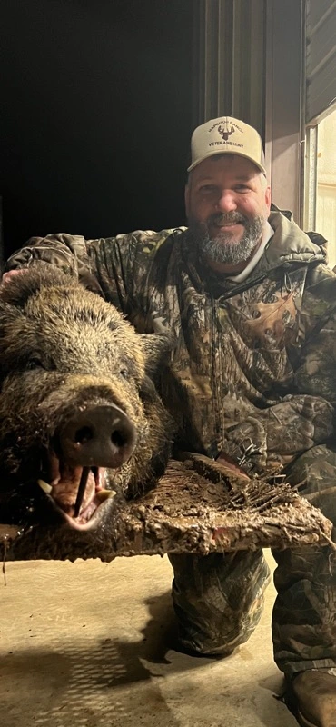 Veteran and guide with a harvested hog at the ranch